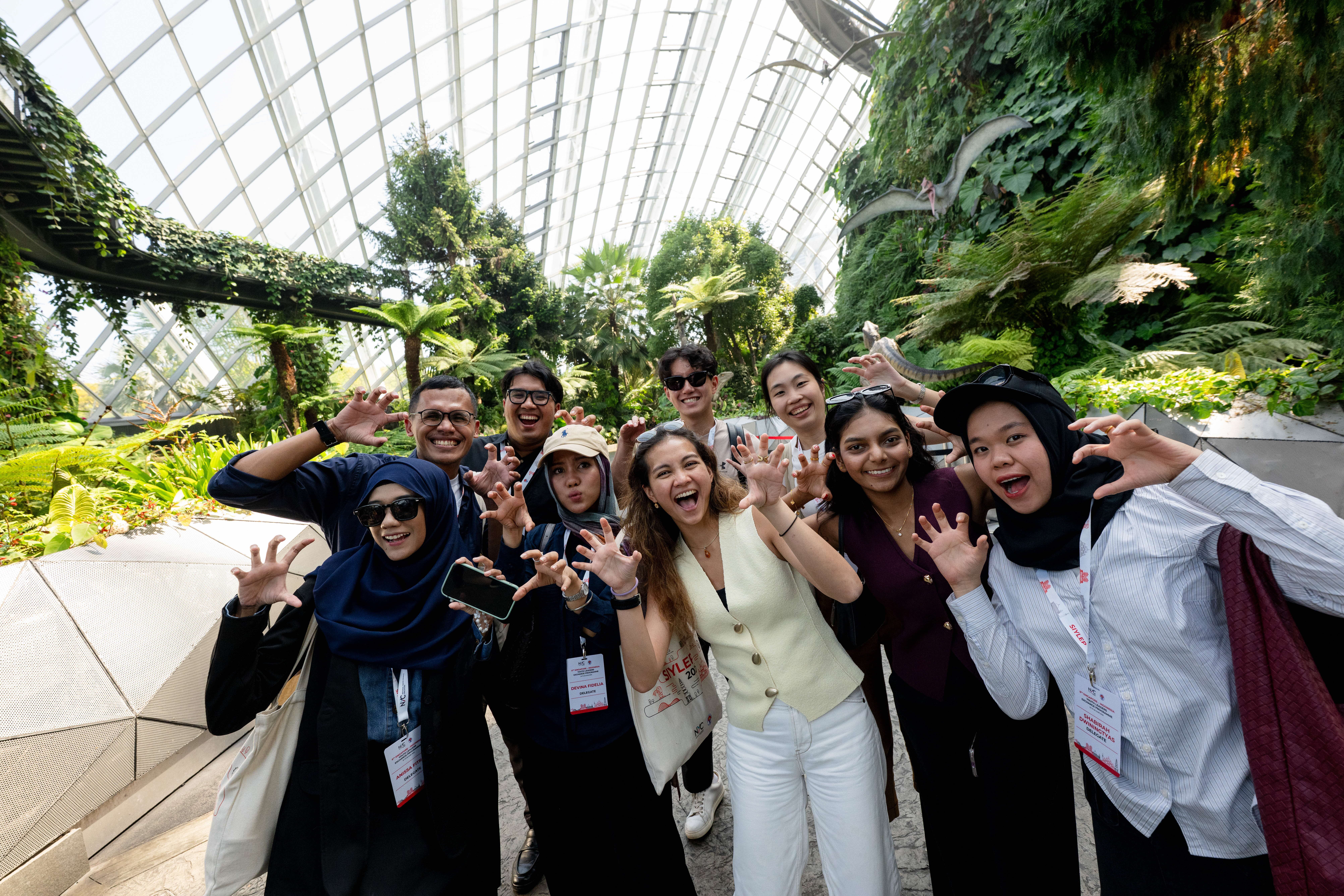 Group of people posing with their hands, doing the roar action, in Gardens by the Bay.